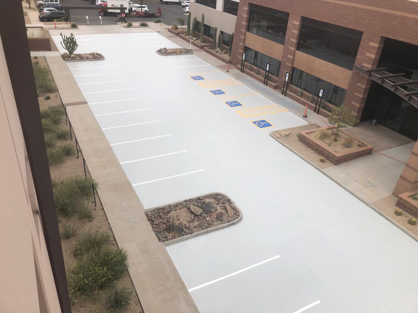 Office building parking deck with a new gray traffic coating, fresh white stripes and blue accessible stalls